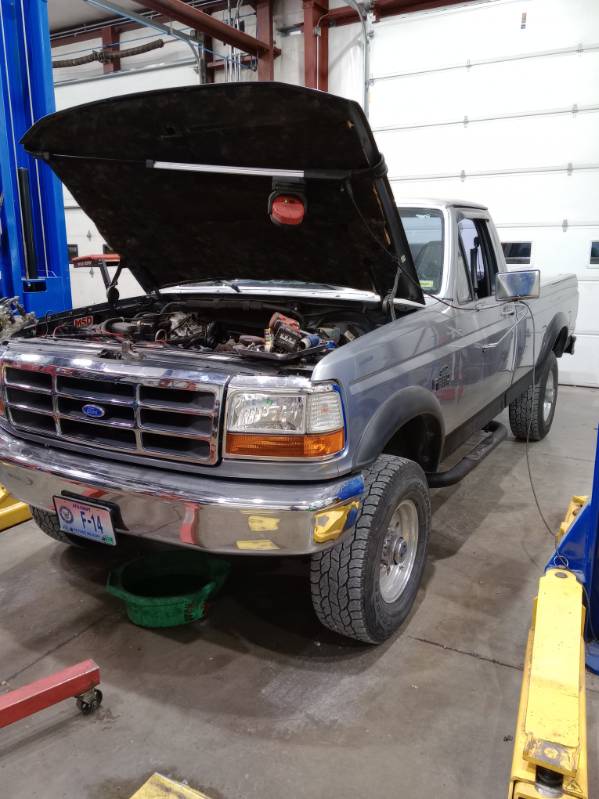An older Ford pickup in the bay with its hood raised